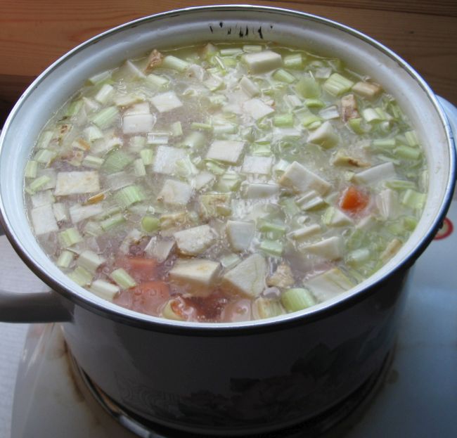 Suppengemüse und Kartoffel zusammen mit Wasser im Topf.